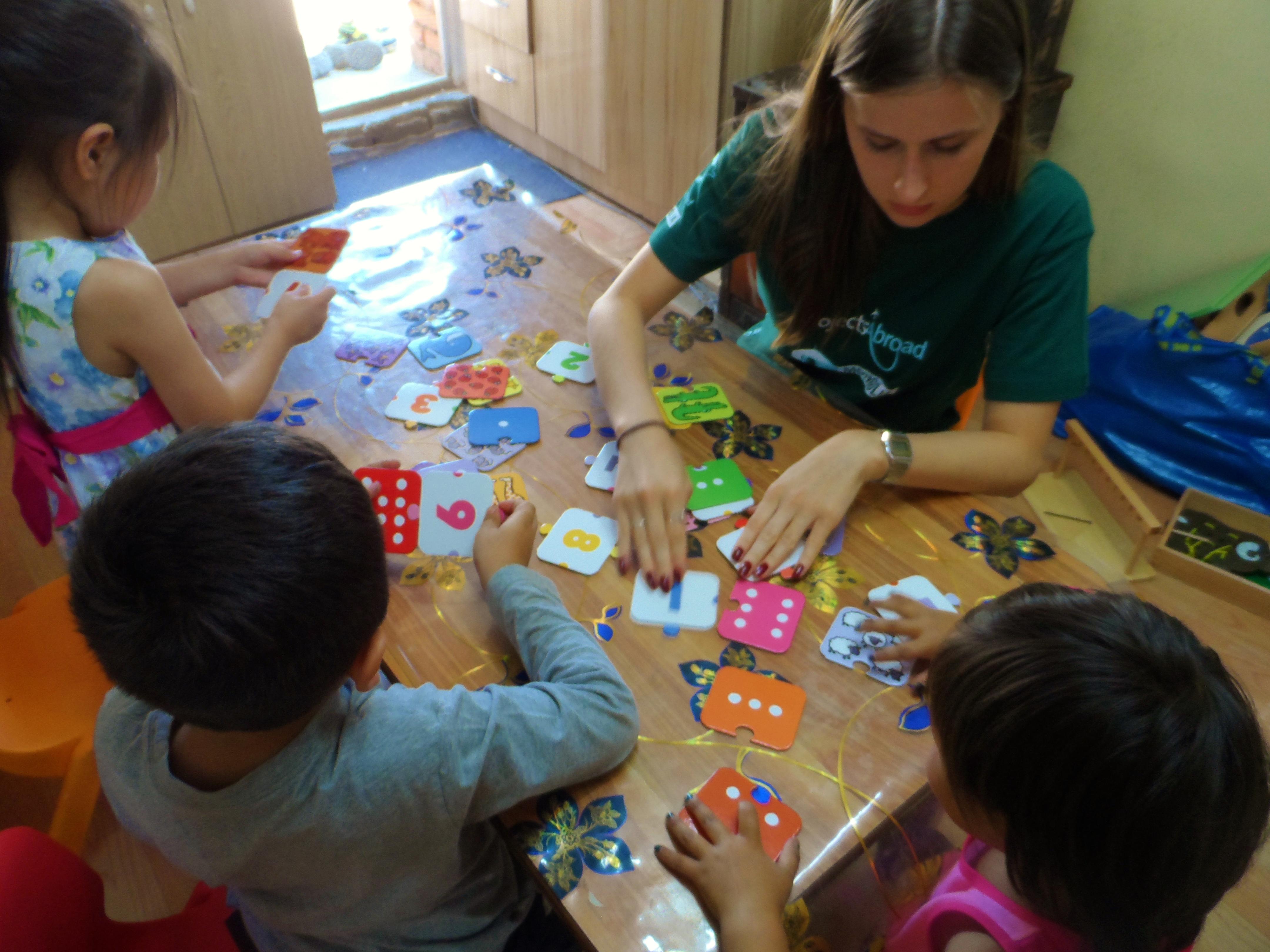Female volunteer teaches an educational activity to children in a care centre during her Childcare Project in Mongolia. Projects Abroad volunteer working with children in Mongolia helps a group of children with mathematic skills at a care centre.